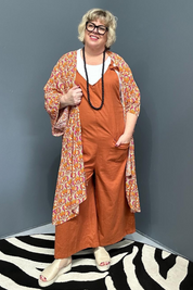 Front view of a plus-size woman wearing the 'BILLIE' stretch linen overalls in rust – relaxed fit with adjustable straps and a flattering design for curvy women